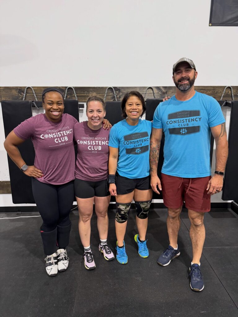 Four CrossFit Notch 8 members wearing matching 2025 and 2026 Consistency Club shirts in the Avon gym